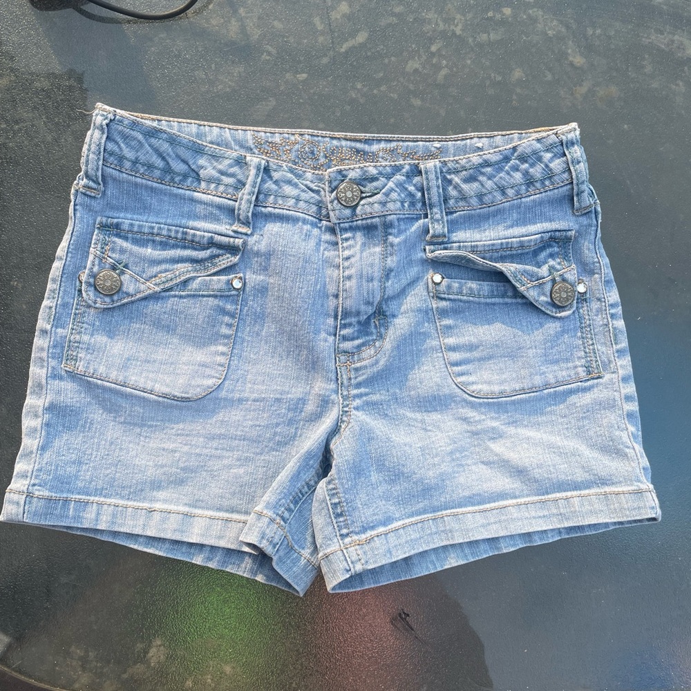 Blue bedazzled denim shorts with green embroidery on back pockets